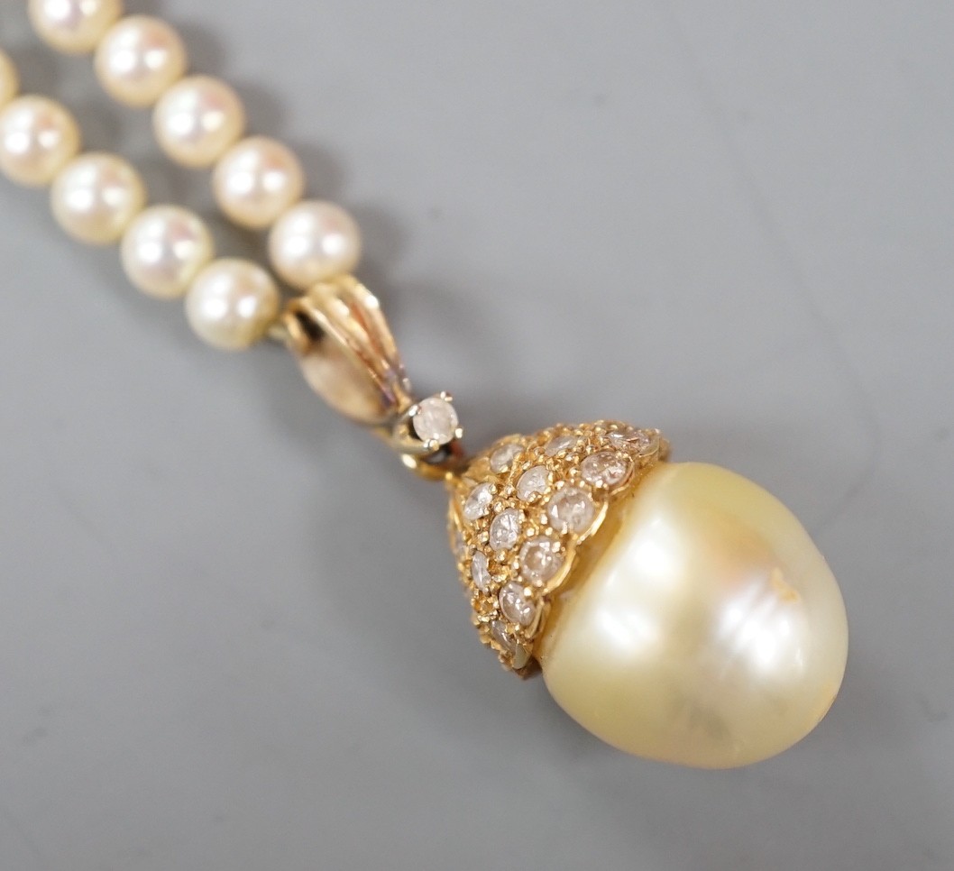 A modern cultured pearl and diamond cluster set drop 'acorn' pendant, overall 23mm on a cultured pearl necklace with 18k clasp, necklace 36cm.